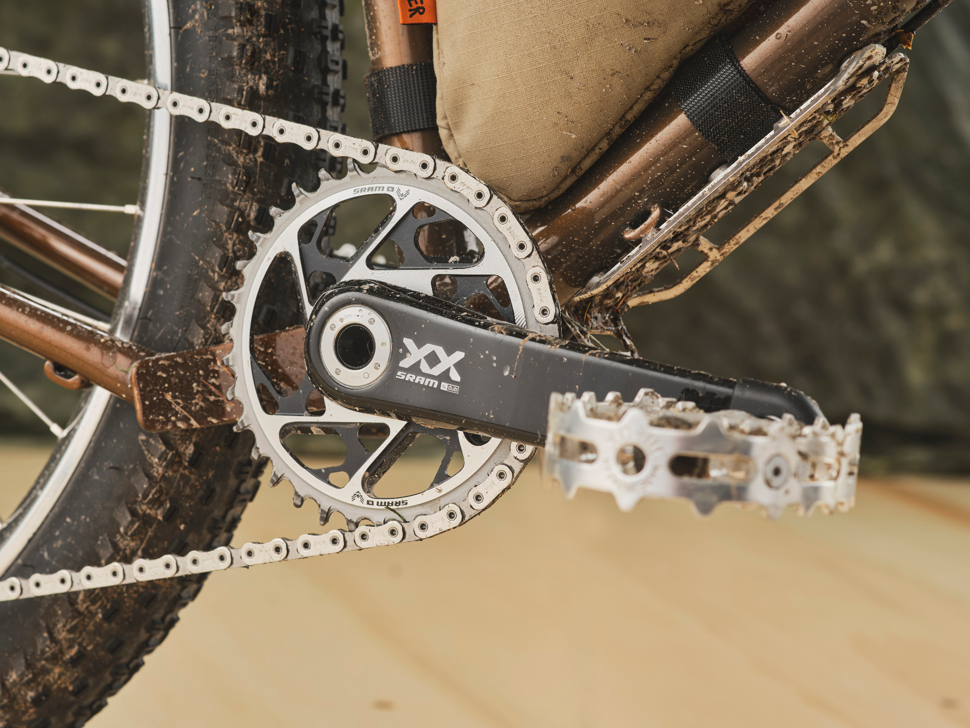 SRAM XX drivetrain detail on a mud-splattered custom steel bike