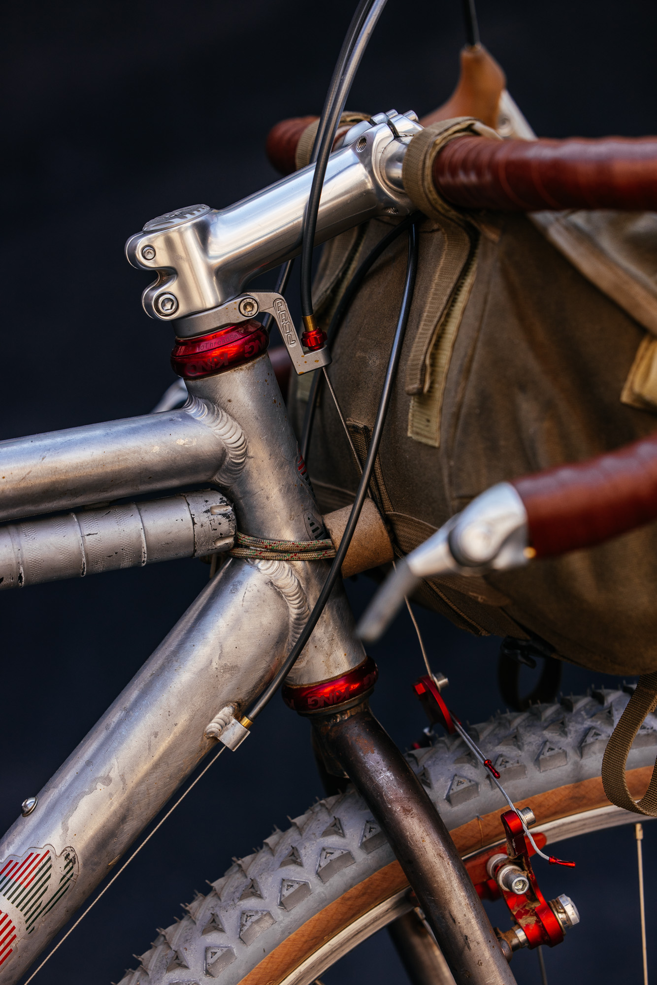 Close-up of a polished steel bicycle head tube with red Chris King headset