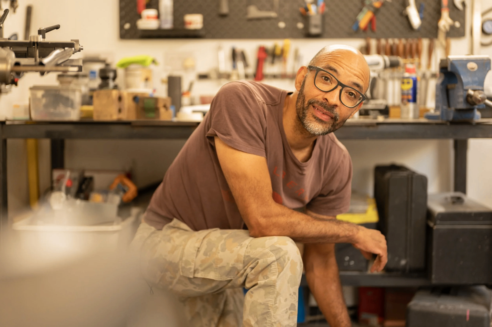 Telbert sitting at his workbench, surrounded by tools