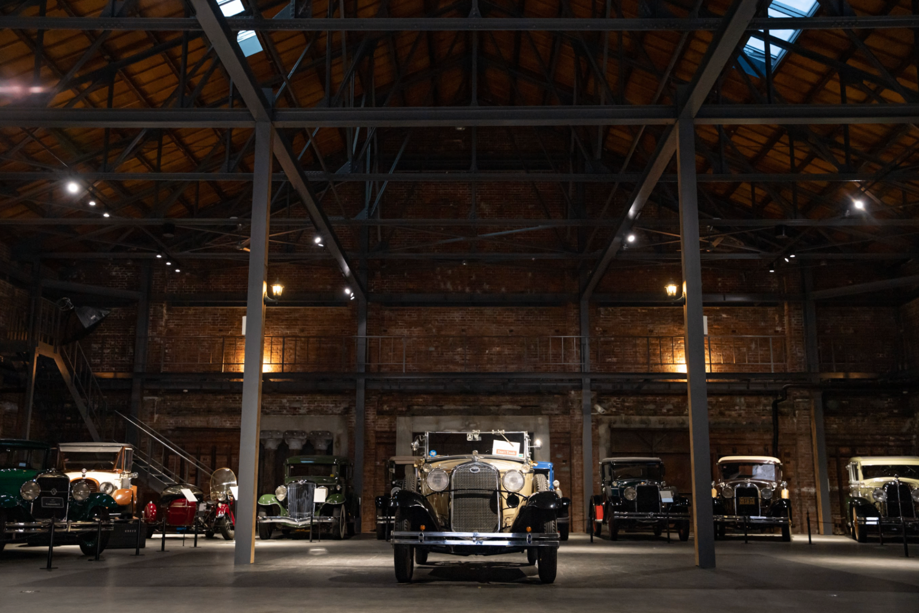 Vintage cars on display inside the GLION Museum's brick and steel warehouse hall