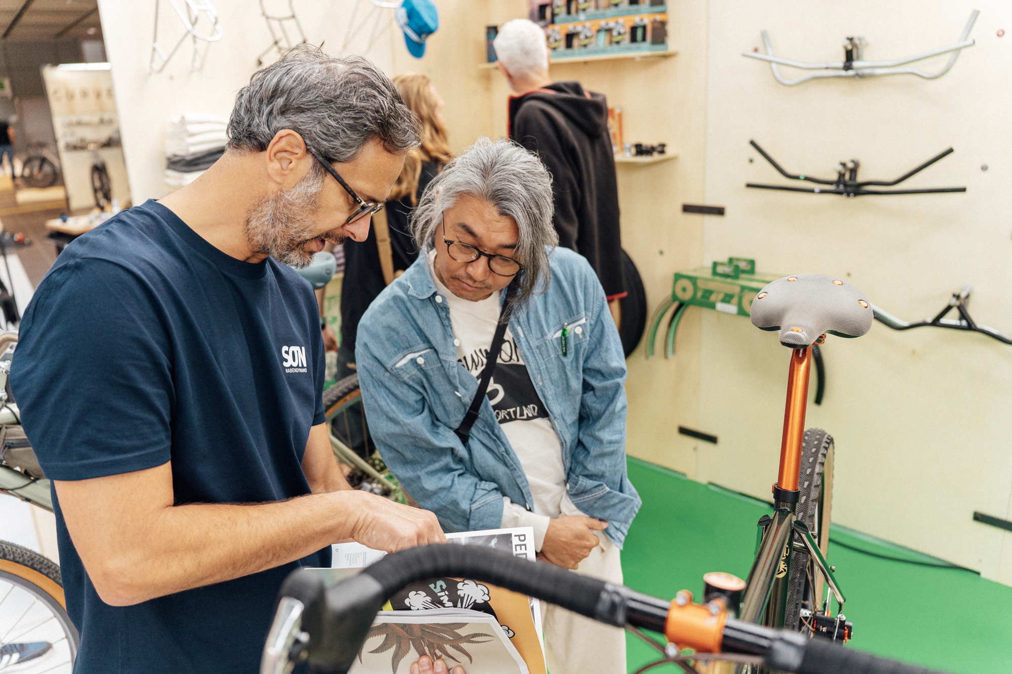 Two visitors examining a handmade bicycle at BESPOKED Dresden 2026