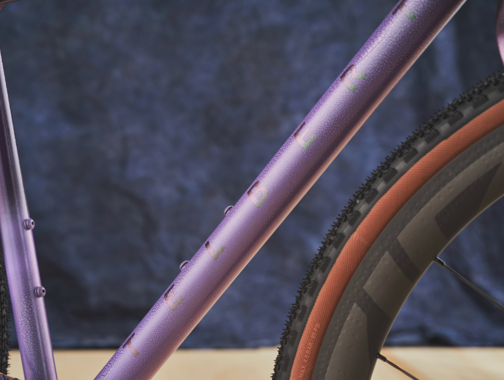 Close-up of Telbert's purple frame showing the textured finish and lettering on the top tube
