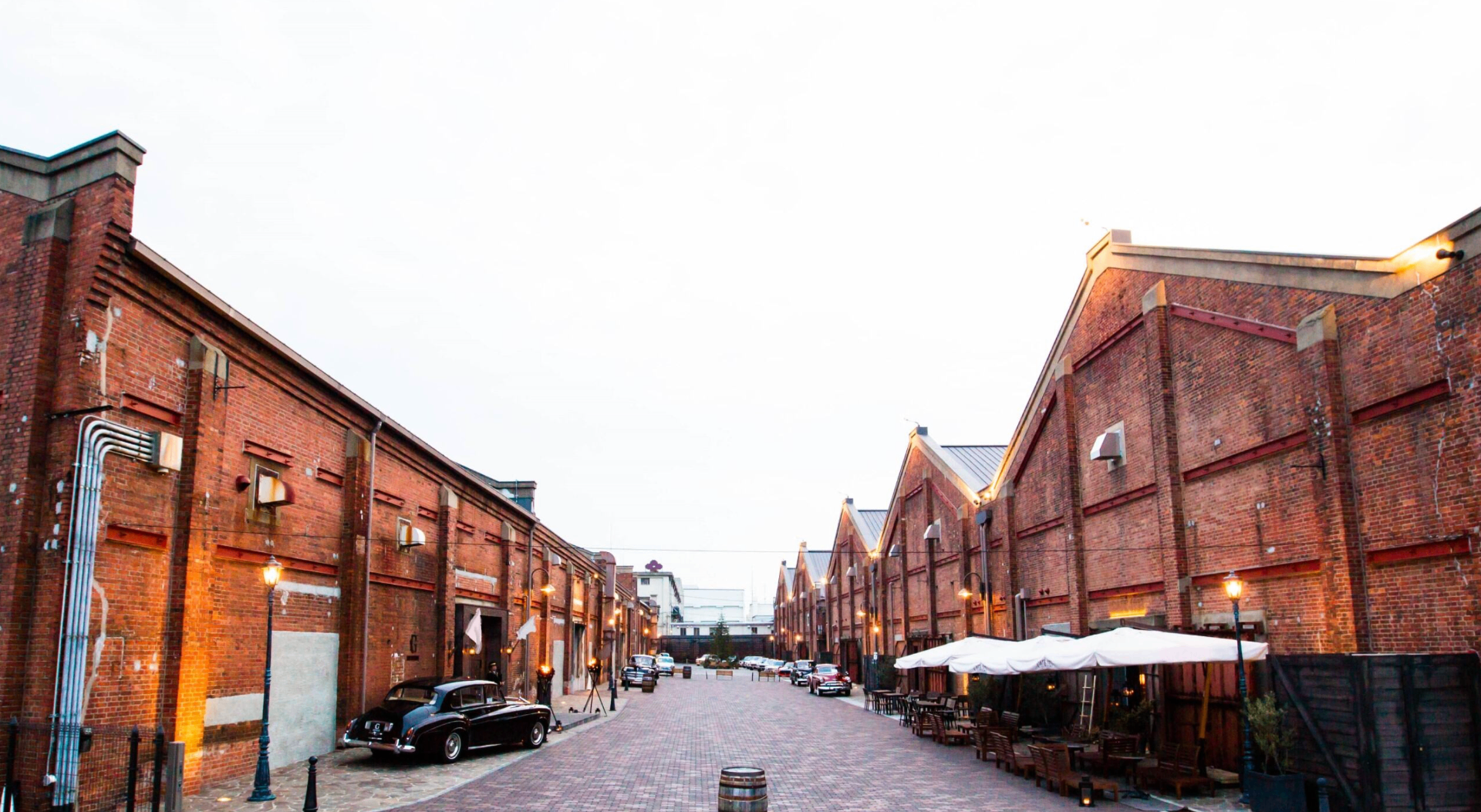 The GLION Museum's red-brick warehouse street with classic cars and outdoor café seating